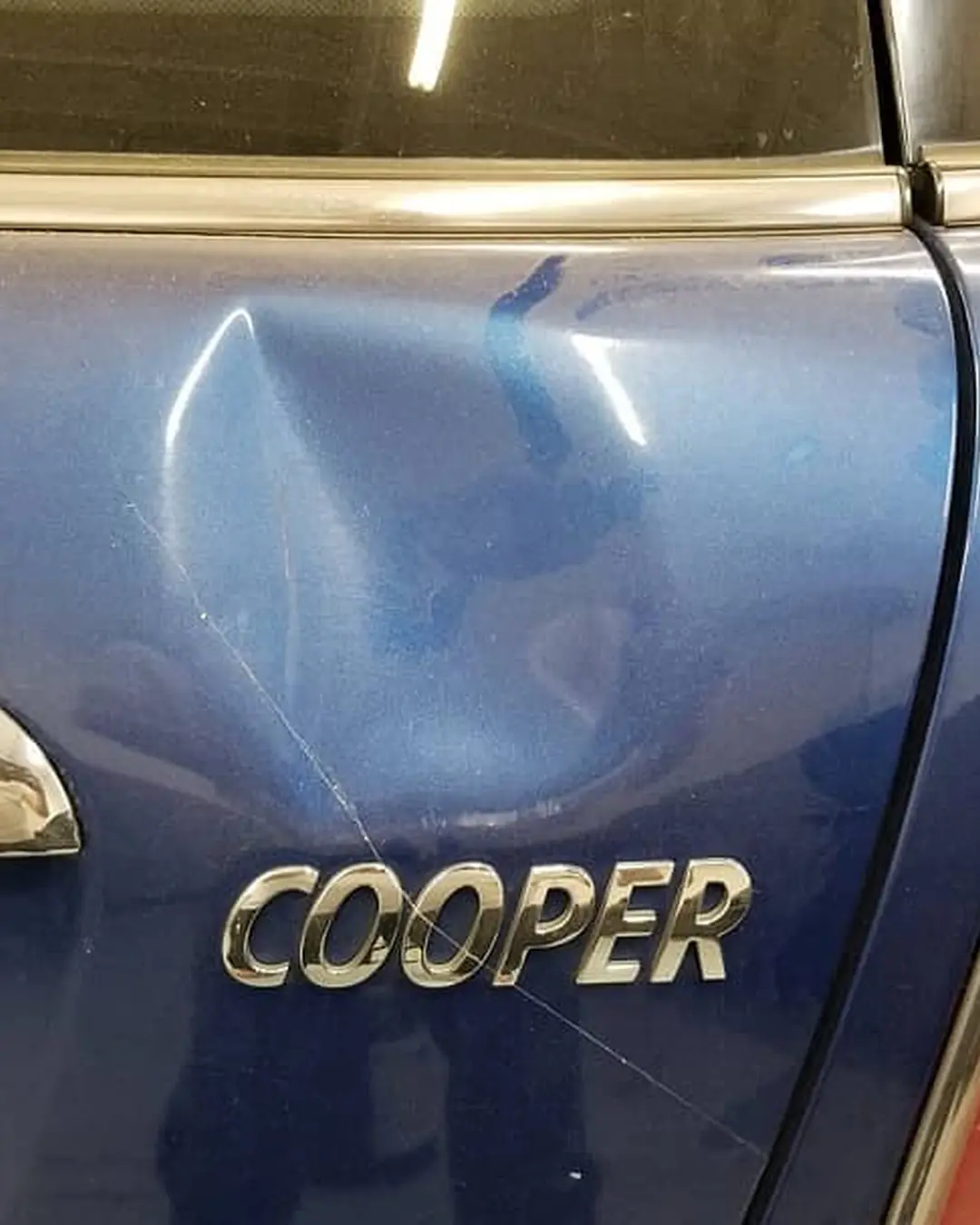Before: Dent in the tailgate of a Mini Cooper